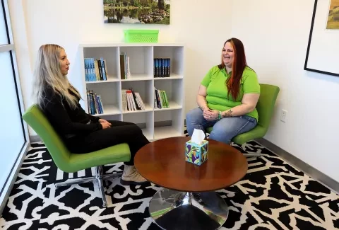 Photo of two women sitting talking in a light-filled room