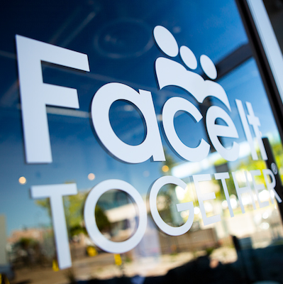 Photo of Face It TOGETHER logo on glass