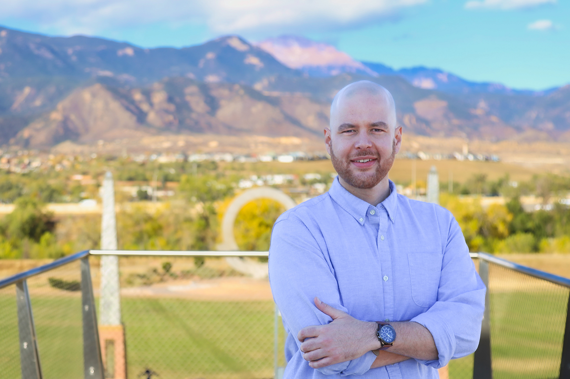 Photo of Denver peer coach Jordan in front of Colorado Springs, CO mountains