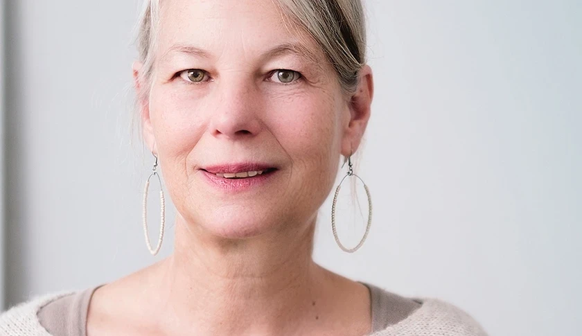 Stock photo of woman with grey and brown hair and hoop earrings 