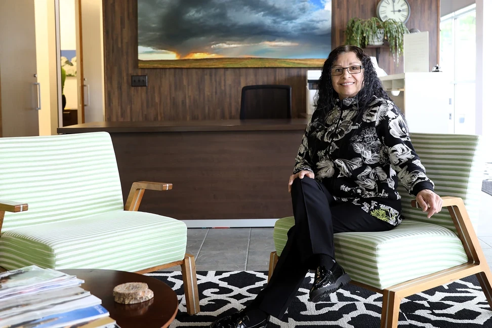 Photo of woman sitting and smiling in office lobby