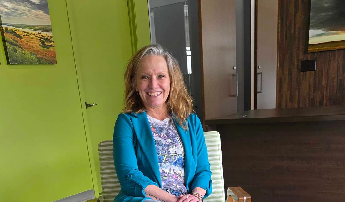 Photo of woman sitting and smiling in office lobby