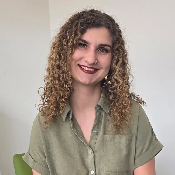 Photo of Jackie, woman with curly hair sitting in office