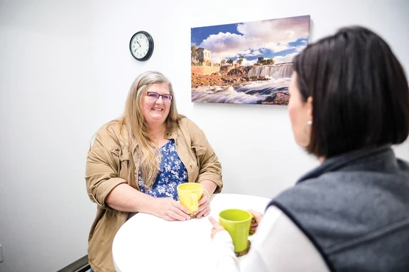 Photo of two women talking over coffee