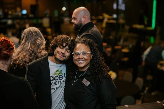 Photo of man and woman with arms around each other smiling at camera